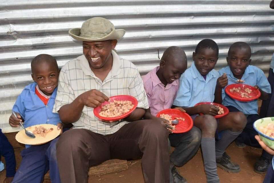 children-enjoying-a-meal-with-adminstrator-image